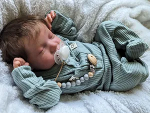 Détail de la poupée reborn Levi endormie avec cheveux réalistes et pyjama vert sauge