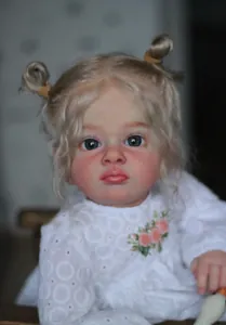 Détail d'une poupée Reborn de 60cm avec cheveux blonds bouclés et robe en dentelle brodée