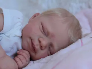 Close-up of lifelike newborn doll with realistic skin texture and purple star pajamas