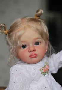 Gros plan d'une poupée reborn de 60cm avec cheveux blonds, yeux bleus et dentelle