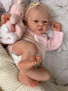 Close-up of 19-inch realistic reborn doll with visible veins and pink knit sweater