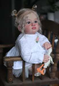 Vue détaillée de la poupée reborn avec chignons blonds et robe en dentelle blanche