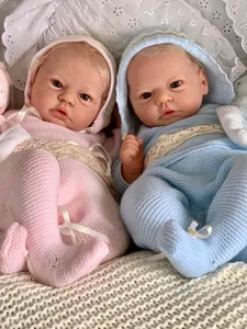 Detailed close-up of 19-inch lifelike reborn dolls with soft knit outfits and lace details