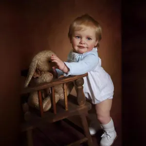 Lifelike 55cm reborn baby doll Zoe with blonde hair and blue eyes in knit romper