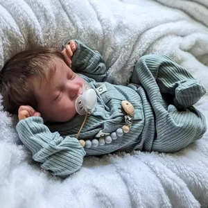Poupée Levi reborn réaliste de 46cm endormie en barboteuse verte sur tapis en peluche