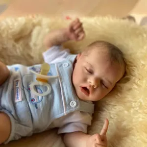 Realistische 18-Zoll Reborn Babypuppe in blauem gestreiftem Overall auf weichem Plüschteppich