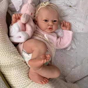 Lifelike 19-inch reborn baby doll with visible veins, pink knit top and plush rabbit toy