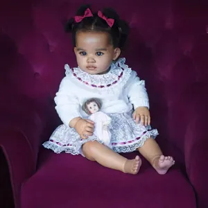 Poupée Reborn réaliste de 55cm avec cheveux bouclés et pull en dentelle sur sofa