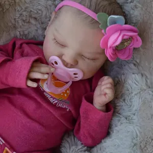 Realistic 19-inch sleeping reborn baby doll with pink flower headband and pacifier