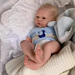 Realistic 19-inch reborn baby doll with visible veins and knit blue sweater in a cradle