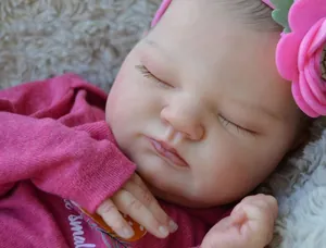 Close-up of a sleeping 19-inch reborn doll with realistic skin and a floral headband