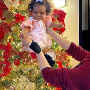 60cm realistische Reborn Maddie Puppe mit dunkler Haut im rosa Spitzenkleid am Baum