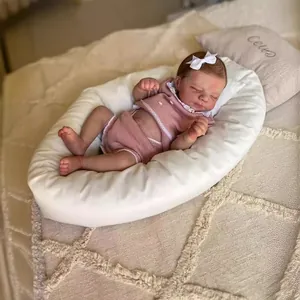 Poupée reborn réaliste de 19 pouces dormant en tricot rose sur un coussin crème doux