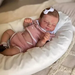 Poupée reborn réaliste de 19 pouces dormant en tenue rose sur un nid d'ange blanc doux