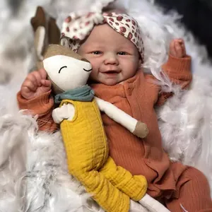 Realistic 19-inch reborn doll with visible veins wearing orange romper and fox plush on white fur