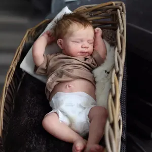 Realistische 49 cm schlafende Reborn-Babypuppe im braunen Hemd in einem Weidenkorb
