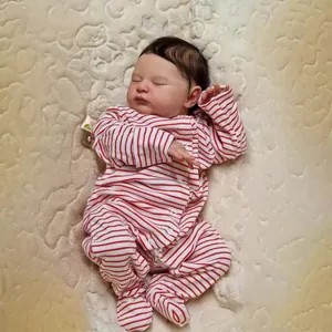 Détail de la poupée Reborn de 20 pouces en pyjama rayé sur une couverture douillette