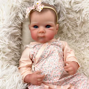 Close-up of Bettie reborn baby doll featuring blue eyes and floral pink outfit