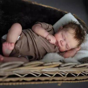 Realistische 49 cm Reborn-Babypuppe schlafend in braunem Strampler auf einer Matte