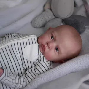 Poupée Cameron reborn 60cm réaliste en barboteuse rayée posée sur une couverture douce