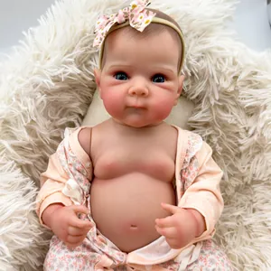 Realistic 18-inch Bettie reborn baby doll with blue eyes and floral outfit on plush mat
