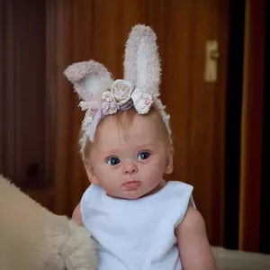 Realistic 24 inch reborn baby doll with blue eyes and floral bunny ear headband