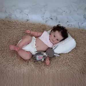 50cm lifelike reborn baby doll with brown hair, pink bib and crochet rabbit toy