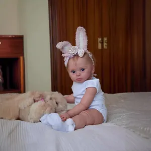 Realistic 24 inch reborn baby doll in white romper with plush dog and floral headband