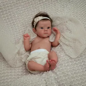 18-inch Bettie lifelike reborn baby doll with brown hair and blue eyes on a white blanket