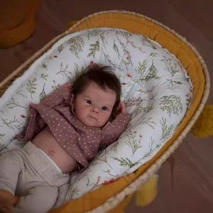 Lifelike 18 inch reborn baby doll with blue eyes in a yellow floral woven basket