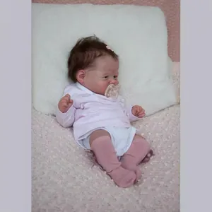 19-inch lifelike reborn baby doll with brown hair, pink outfit and pacifier on plush