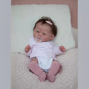 Realistic 19-inch reborn baby doll with pink accessories on a soft textured blanket