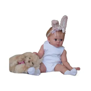 Realistic 24-inch reborn baby doll in white romper with pink bunny headband and plush toy