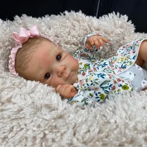 18 inch lifelike reborn baby doll Bettie in floral romper with pink headband on plush rug