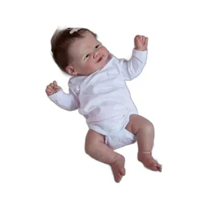 Lifelike 19-inch reborn baby doll with brown hair, pink bow, and white long-sleeved bodysuit