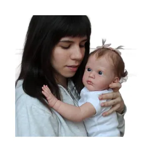 Poupée bébé reborn réaliste de 24 pouces en body blanc avec des nœuds roses sur fond blanc