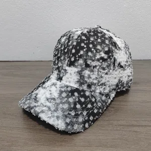 Close-up of distressed baseball cap with silver sequins and frayed edge details