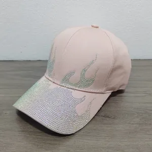 Dettaglio del cappello rosa con decorazioni a fiamma in strass e tessuto di cotone