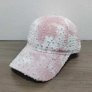 Detail of pink tie-dye baseball cap featuring silver sequins and distressed fabric texture