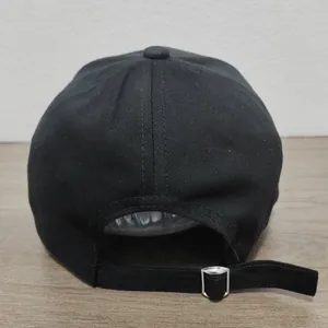 Dettaglio della fibbia in metallo e del cinturino nero sul retro del cappellino