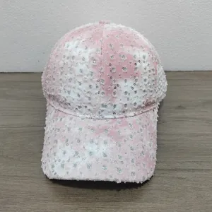 Detailed macro view of pink denim baseball cap with silver sequins and distressed edges