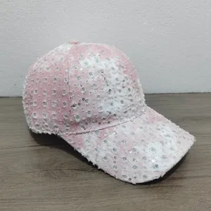 Close-up of pink and white distressed denim baseball cap with shiny silver sequins details