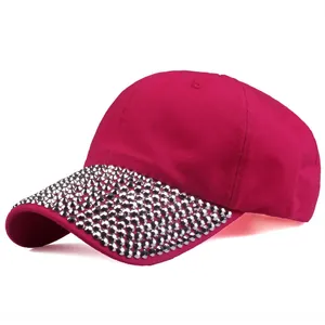 Detailed close-up of shiny rhinestones on the brim of a pink cotton baseball cap
