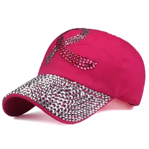 Détail d'une casquette en coton rose avec ruban en strass et visière incrustée