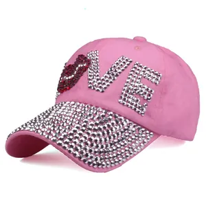 Detailed view of pink cotton baseball cap featuring LOVE rhinestone letters and brim