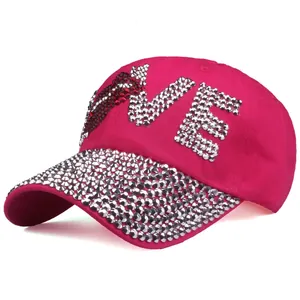 Macro detail of rhinestone LOVE lettering and sparkling crystals on pink baseball cap