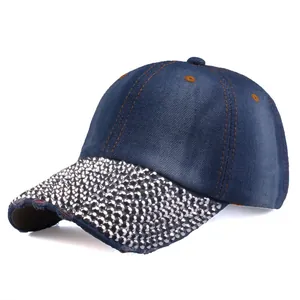 Close-up of sparkling rhinestones and yellow stitching on navy denim baseball cap