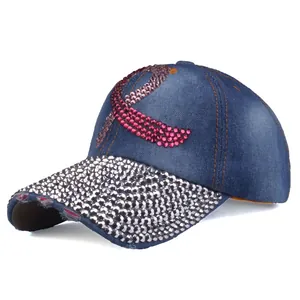 Détail de casquette en jean bleu avec ruban en strass rose et visière brillante