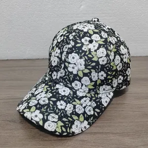 Dettaglio ravvicinato di un cappello da baseball nero con motivo floreale bianco su legno