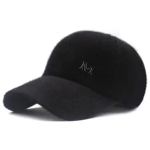 Close-up of black plush baseball cap with fluffy texture and silver metal M logo